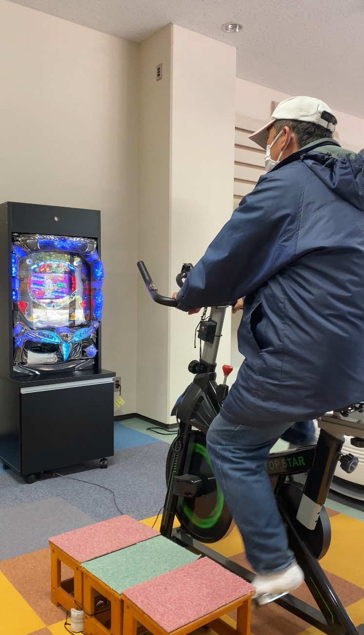 自転車型機能訓練パチンコを利用している様子 1