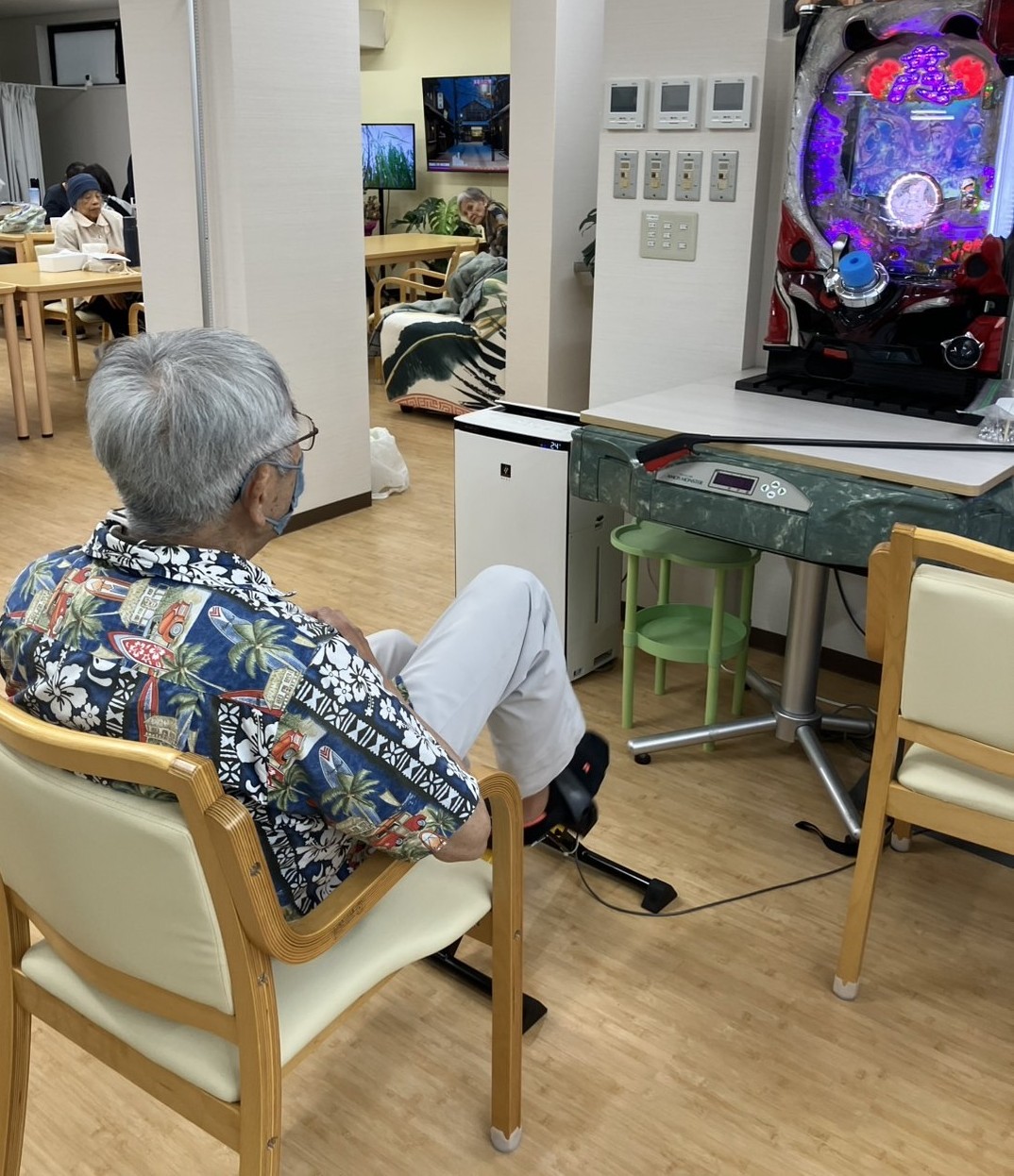 福祉施設で足漕ぎ運動を行いながらパチンコを楽しむ利用者の様子