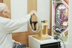 機能訓練用のハンドル操作器具とパチンコ台を併用している様子（活用例）