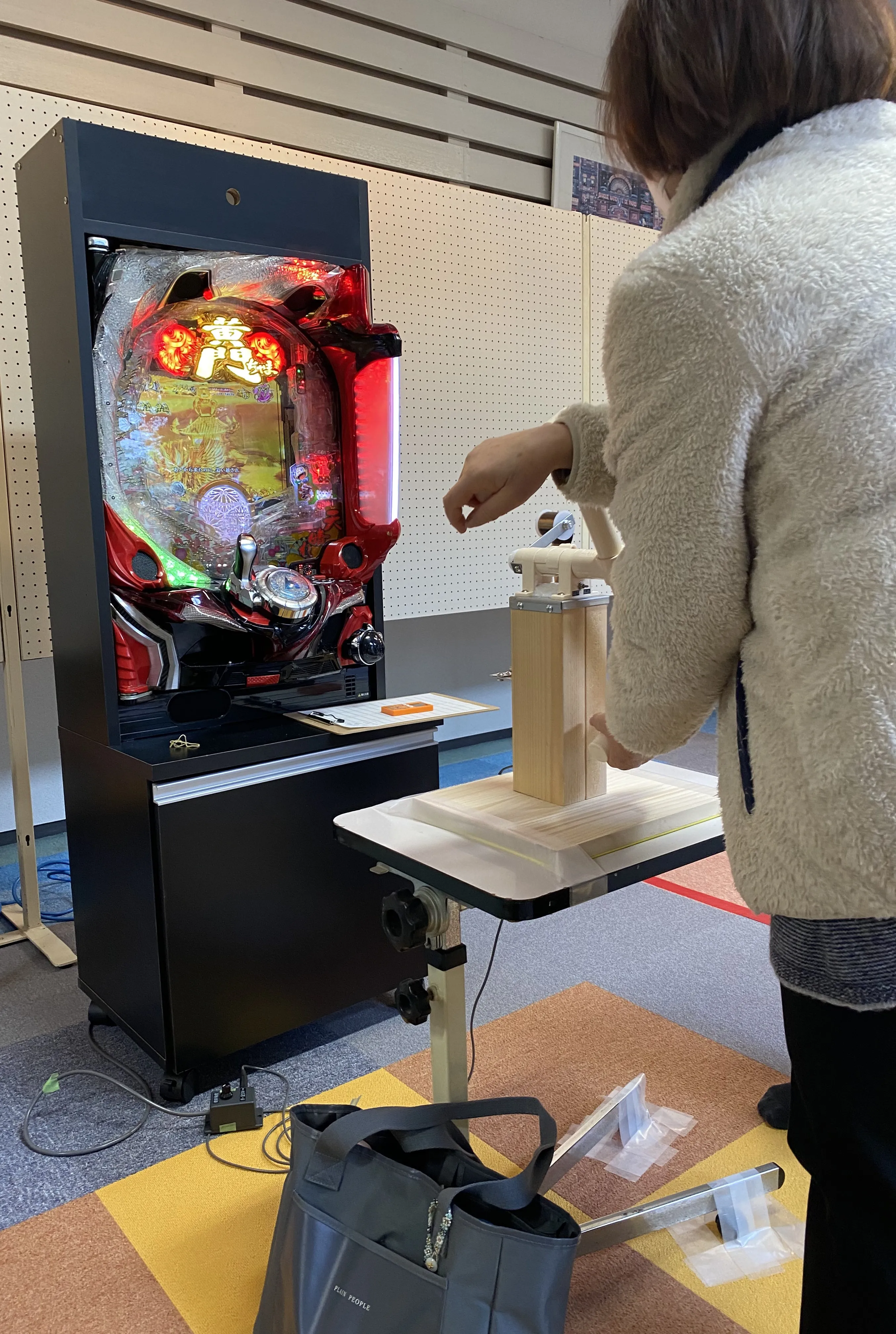 上肢の運動器具を操作しながらパチンコを活用する利用者の様子