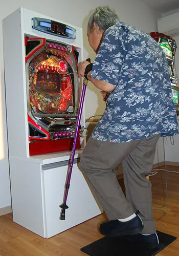 補助具を使いながら介護予防用パチンコで下肢の運動に取り組む様子